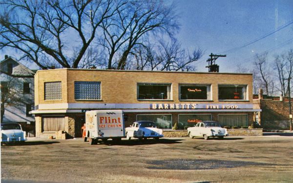 Barnett’s restaurant 1950s box shaped 2 story brick building, glass brick wall to the left, cars and parking area 1950s color photo