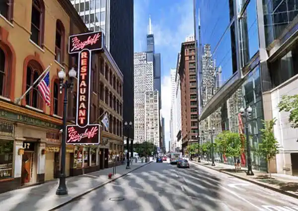 Berghoff neon sign and beyond to the right the Sears Tower in Chicago, Adams street runs towards the tower