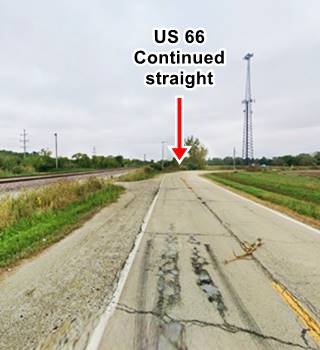 color, highway with railroad to the left curves right, fields and trees