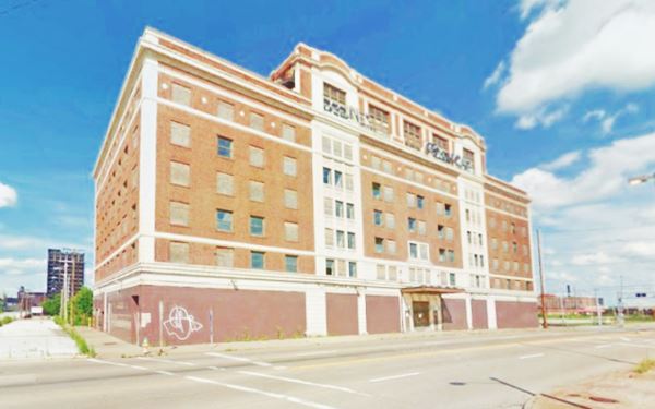6-story red-brick building, vacant, with grafitti, on an empty street