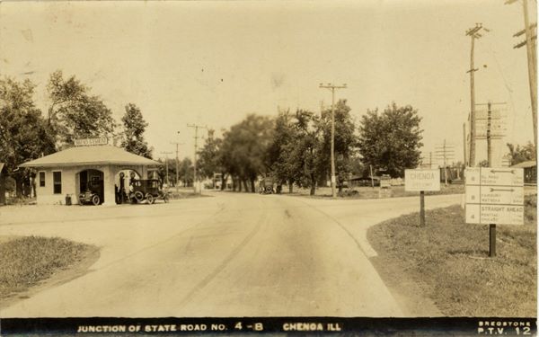 black and white 1922 crossroads IL-4 and 8, gas station on the left corner with 2 cars under canopy, car driving away on rte 4