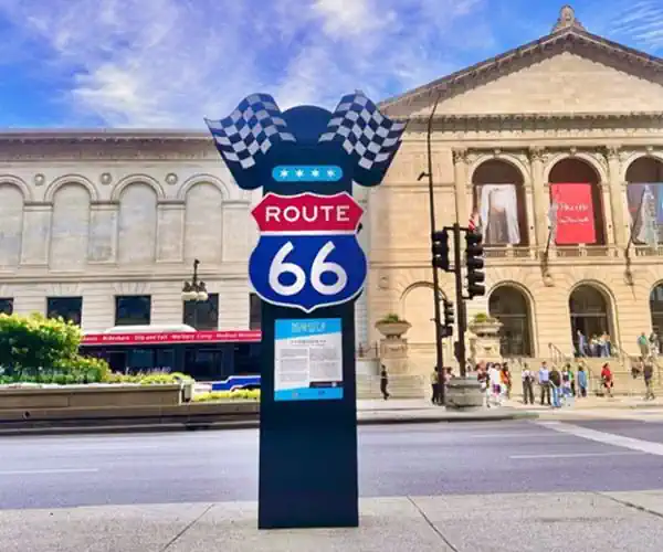 black column topped by black and white checkered flags and US 66 shield in red, white and blue