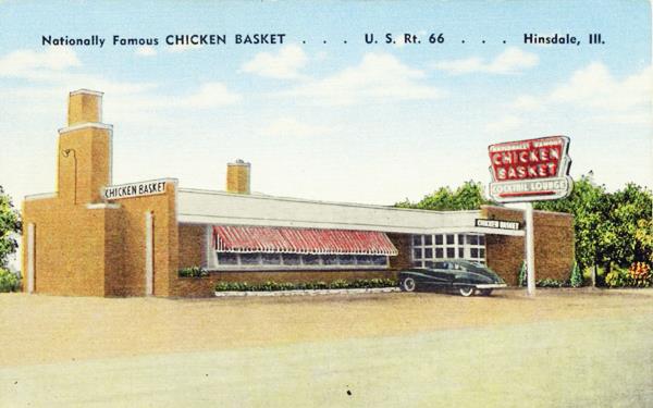 1950s postcard Chicken Basket US66 linen color postcard 1950s, car parked by brick building with large windows with awnings, single story, neon sign to the right CHICKEN BASKET written on it