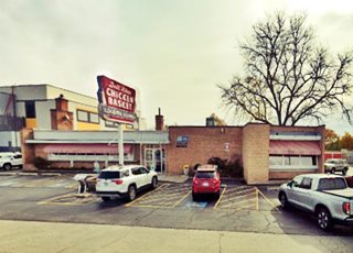 brick building, large windows, single story, vintage neon sign, cars parked by it, a restaurant seen from US66