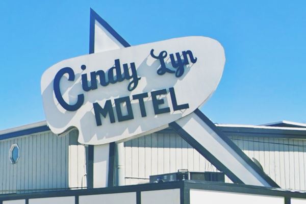 Cindy Lyn Motel Googie neon sign US66 Cicero oval shaped neon sign reading CINDY LYN MOTEL set on a sharp angle shaped base, in dark green letters on white background