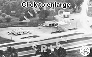 Chenoa Conoco US 66, 1966 Black and white, 1966, aerial view icebox gas station to the right at an intersection with a cafe to the left. Cars, drive, trees