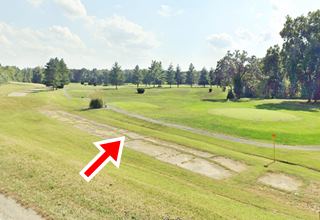 narrow concrete roadbed curves by a golf course seen from IL-4 hwy