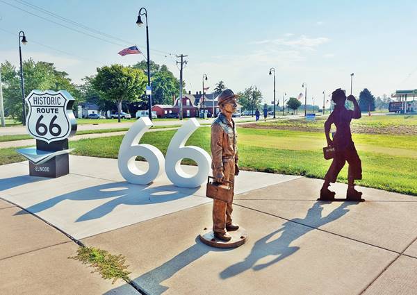 Wayside Exhibit statues, Elwood US66 Illinois Left to right: US 66 shield and two large number 6. A bronze miner statue and a steel sheet shaped like Rosie the riveter in a park