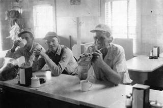 1954 Fern’s Cafe customers Black and white 1954. Three men at a counter of a diner, having coffee
