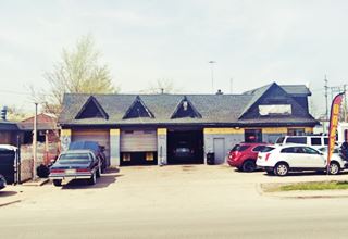 auto dealer, former gas station with cross gabled roof over service bays and office