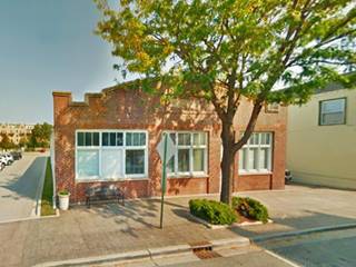 1925 red brick curved roof garage with large windows facing street, a garage