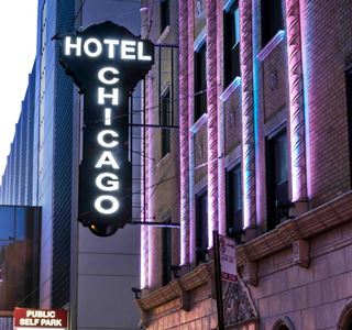 key shaped Neon sign lit at night, white glowing: CHICAGO HOTEL
