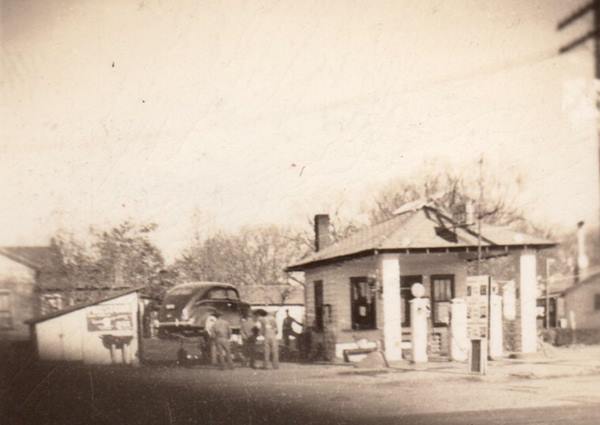 Illico on US66 in McLean, 1948 black and white 1948 photo hip rof gas station, men, car on ramp, shed seen from US66
