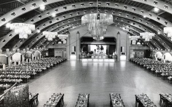 black and white photo, large dance floor under curved roof, with tables around it, and balconies on the perimeter