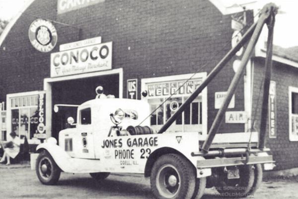 black and white 1940s, conoco garage and tow truck in front of it