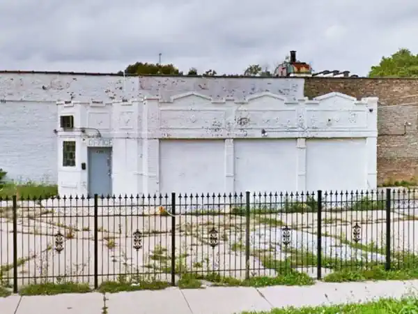 1 story, former brick gas station. Parapet with crenels, offic on canted corner, 3 service bays