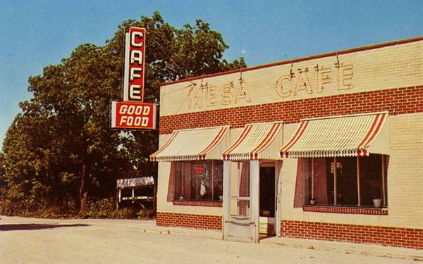 Color 1950s postcard photo: brick faced Cafe with red and white neon sign stating:CAFE-Good Food