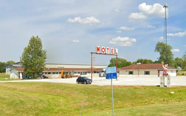 old Motel, white gravel courtyard, Motel sign, Big Boy statue and cafe seen from Route 66