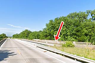 Old 1940s bridge trees beyond, river beneath, seen from the other lanes of US66
