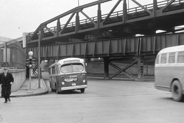 Ogden Viaduct 1950s black and white 1950s steel viaduct over railroad bridge and an underpass, buses, traffic light, man in overcoat
