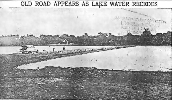 1954 dry Lake Springfield and US66 viaduct resurfaces black and white newspaper photo 1954: viaduct with car parked on it by a beach with people, low water level lake shows viaduct cutting across it