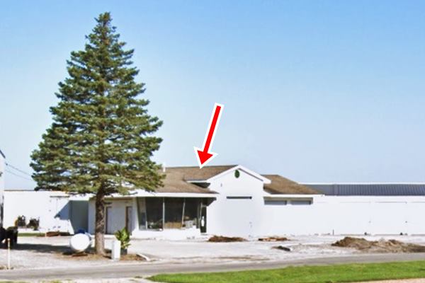 hip roof building, white, former gas station, pine tree to the left