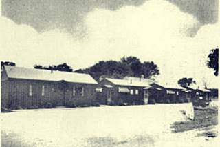1940s Pioneer Motel Broadwell black and white cabins with gable roofs, postcard of a motel