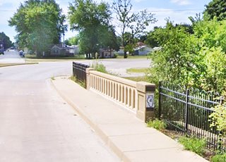 Bridge on US 66 with IL Hwy 4 sign on it trees and and homes beyond, US 66 crossing it