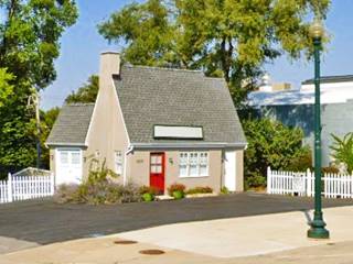 gable roof with chimney, a cottage shaped former Pure Oil service station, with parking area, on a corner