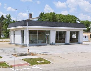 2019, color, box shaped former Shell gas station on a corner seen from US66, glassed office 2 multi-pane service bays to the right