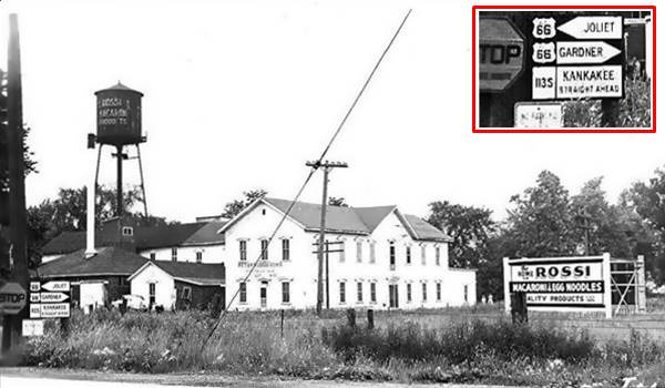 1930s Rossi macaroni plant in Braidwood US66 Illinois black and white 1930s factory 2 story, many buildings, gable roof, water tank signs and on the lower left, Road signs with US66 shields. Inset upper right: enlarged view of the road signs