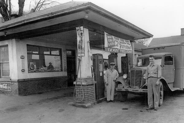 Shorty’s service station c.1940s Lemont IL black and white 1940s, two men by truck in a gas station with pumps under hip roof