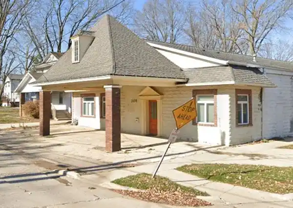 hip roof over canopy of former gas station, now a home