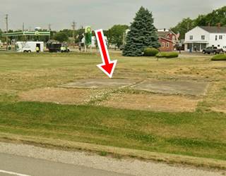 color, concrete driveway in a grassy area, the remains of a gas station