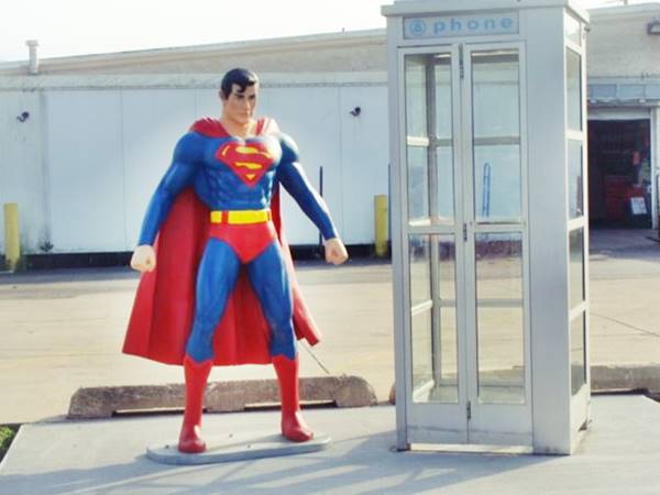 life sized fiberglass statue of Superman by a phone booth