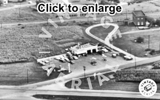 Chenoa Texaco US 66, 1966 Black and white, 1966, aerial view icebox gas station, 2 bays, corner office on an intersection with US66, railroad behind, and a 2 story building, cars, pumps, sign