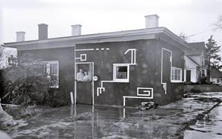 1949 Former Farr Texaco Lexington IL Black and white, 1949, man and woman look out of doorway window of a home with a flat roof