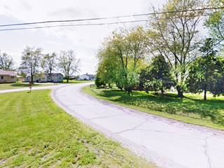 soft curve from north to west of a street in an uraban setting, homes, trees, lawn