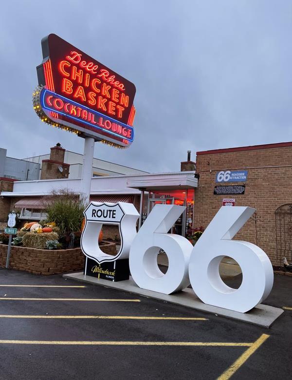 US66 centennial marker in the Chicken Basket, Willowbrook Route 66 shield hollow, with WILLOWBROOK in its pedestal, and two numbers six, all white, large, by Chicken basket lit up neon sign