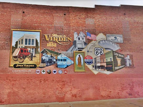 a mural painted on a red brick wall, depicting the history of Virden