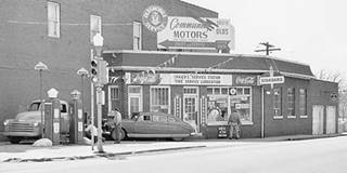 Ward’s Standard Station US66 Wilmington small narrow angled Standard Oil gas station on a corner, US 66 runs to the right, traffic light, truck, car, attendant and 2 pumps
