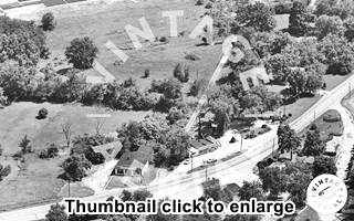 black and white aerial photo, forest, motels and gas station and a curving US 66 between them in 1968