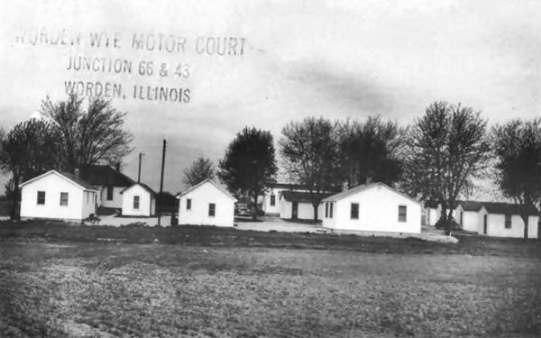 black and white photo 1930s with cabins among trees and stamped with text: " 
Worden Wye Motor Court Junction 66 & 43 Worden, Illinois"