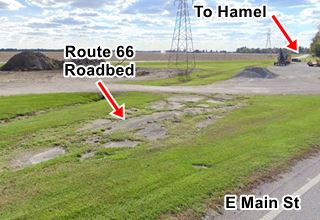 slab of cracked concrete with grass, road in the distance, fields