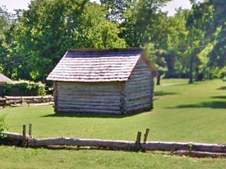 Baxter log cabin in Baxter Springs replica of a log cabin in a field
