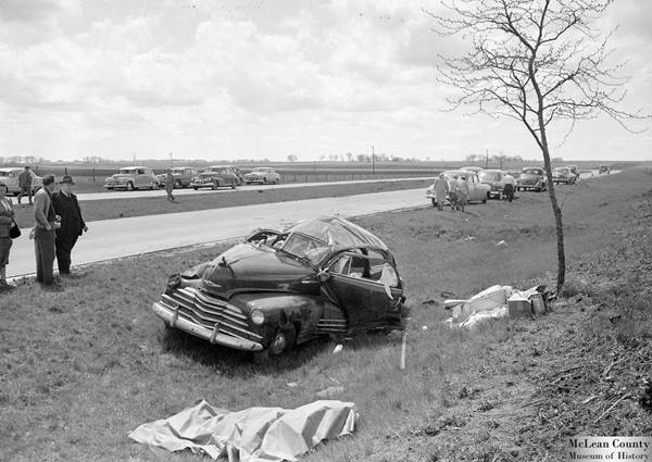 black and white photograph of a car and dead person