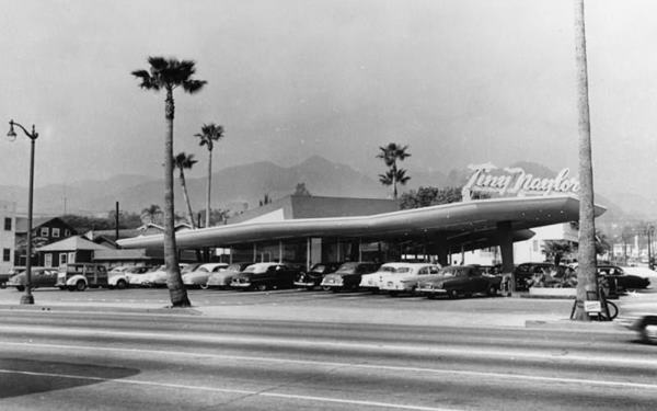 vintage black and white photo of Tiny Naylors winged canopy, palm trees and 1950s cars