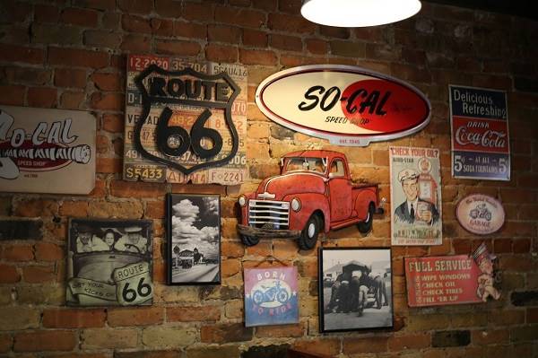 brick wall with vintage enamel signs, photos and US 66 memorabilia