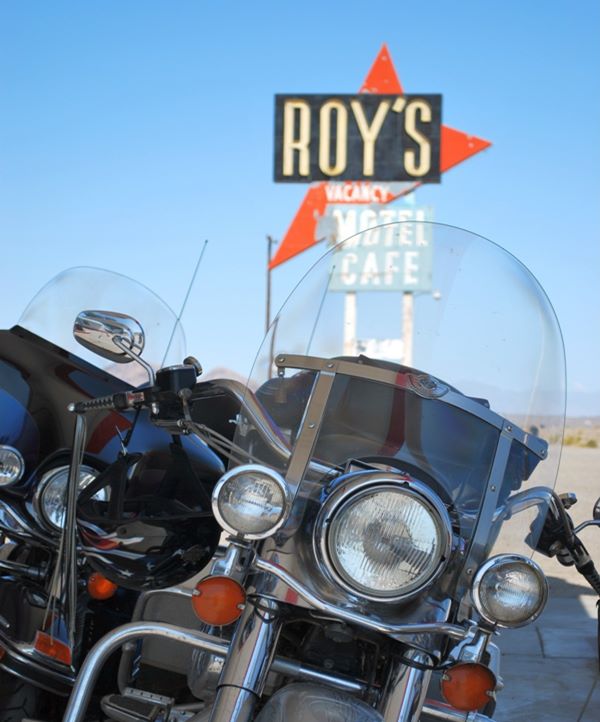 Motorcycle and behind it Roy’s Cafe neon sign