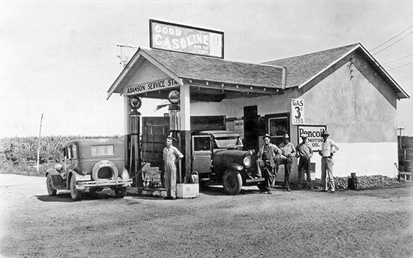 1930s black and white photo gas station, cars and men